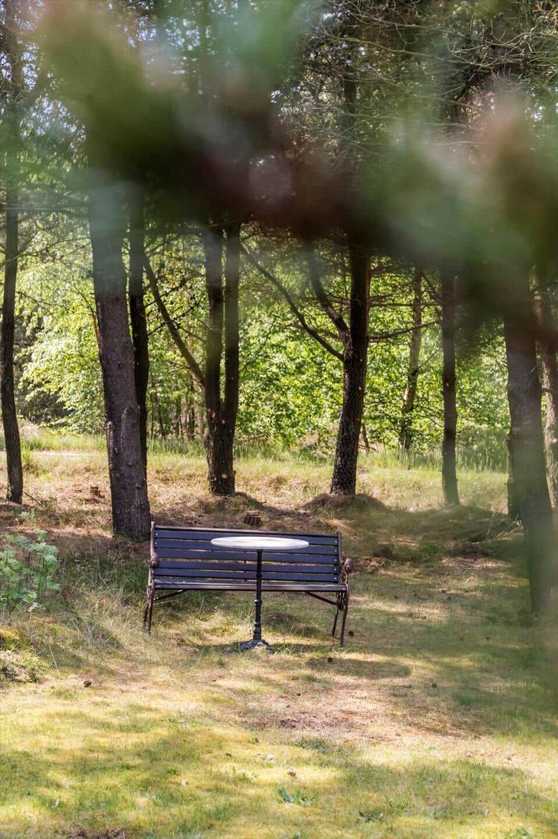 Ein schwarzer Metallbank mit runder Tischplatte im Wald.
