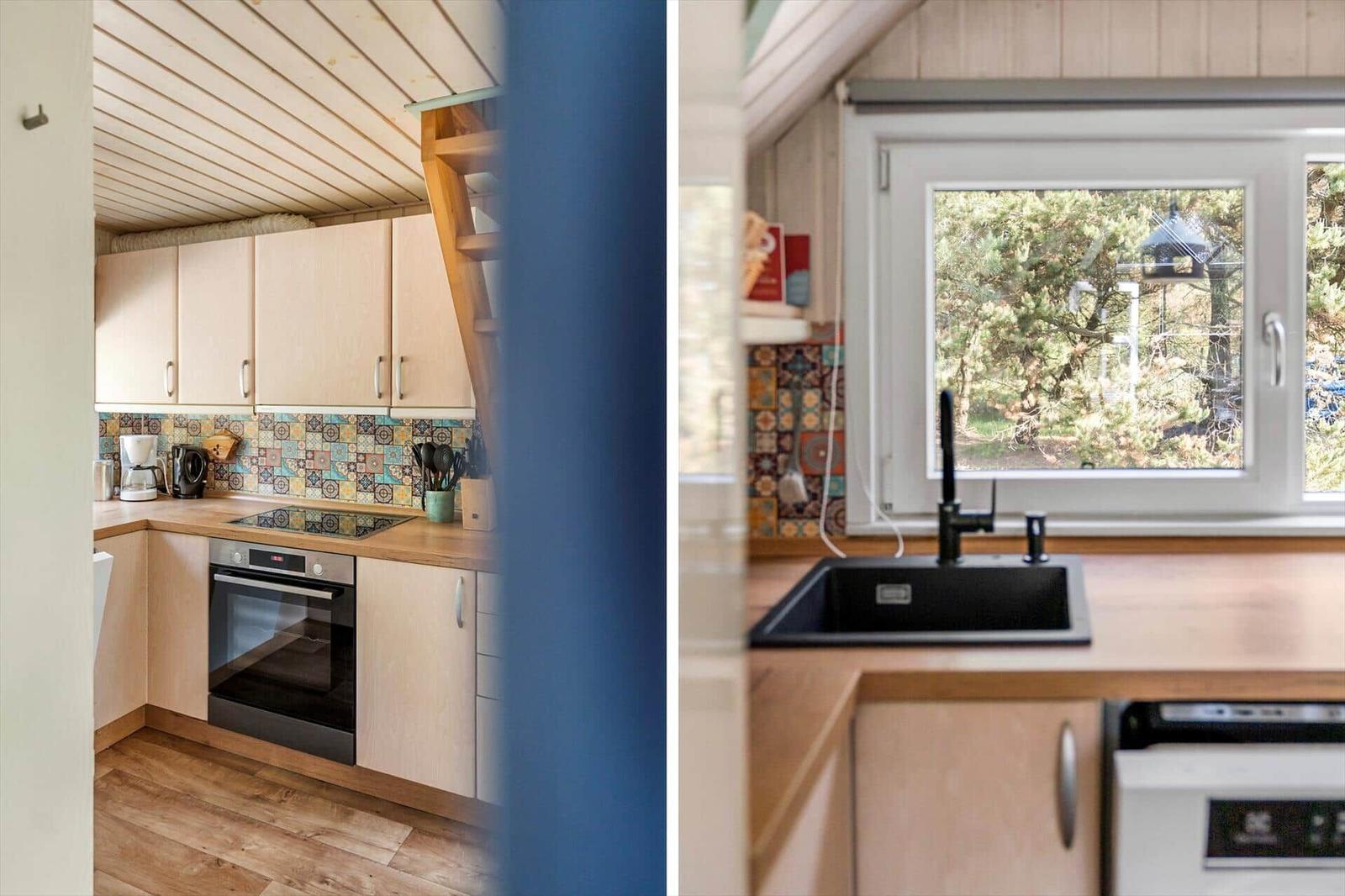 Küche mit Holzschrank und Steinplattenwand. Fenster mit Blick auf Garten.