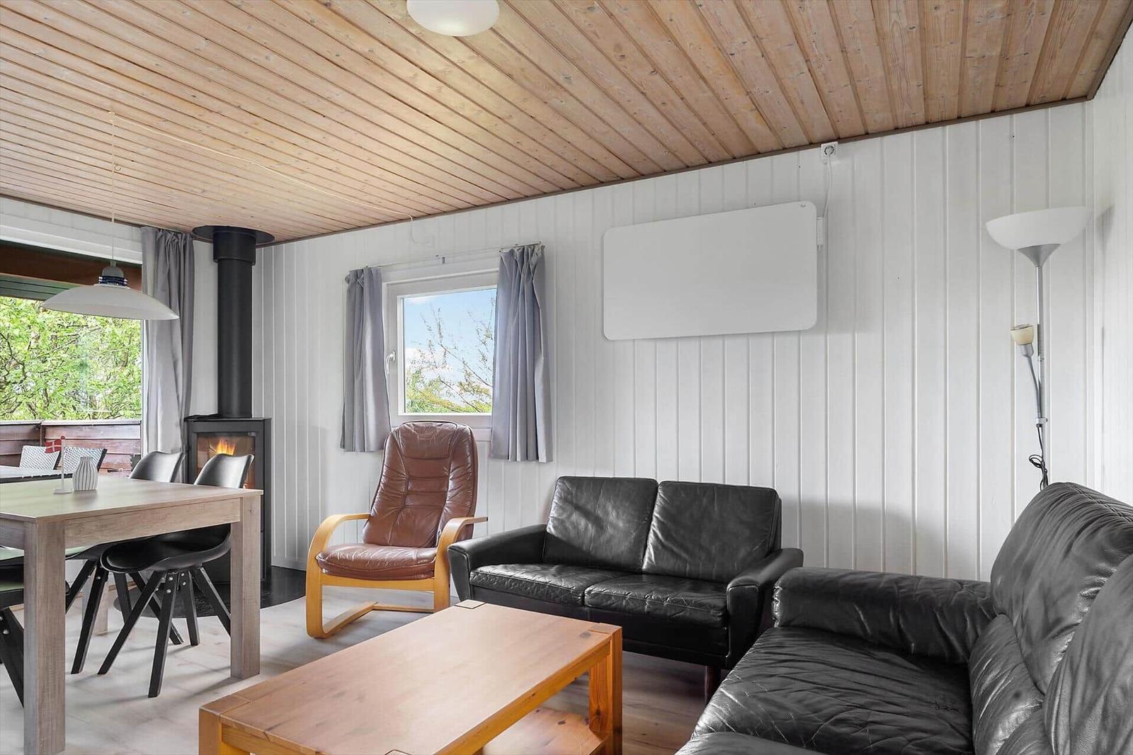 Wohn- und Essbereich mit Kamin, Ledersofa und Holzmöbeln.