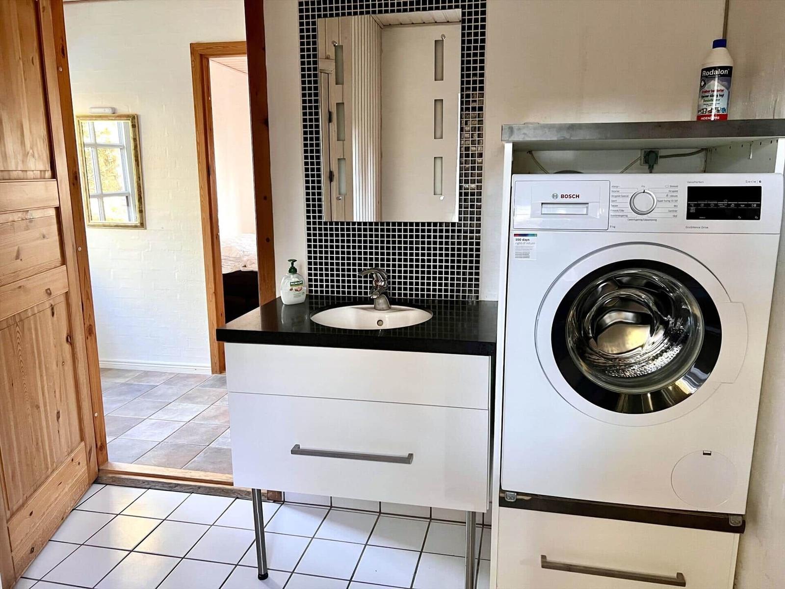 Waschmaschine und Waschtisch mit Spiegel und Mosaikwand