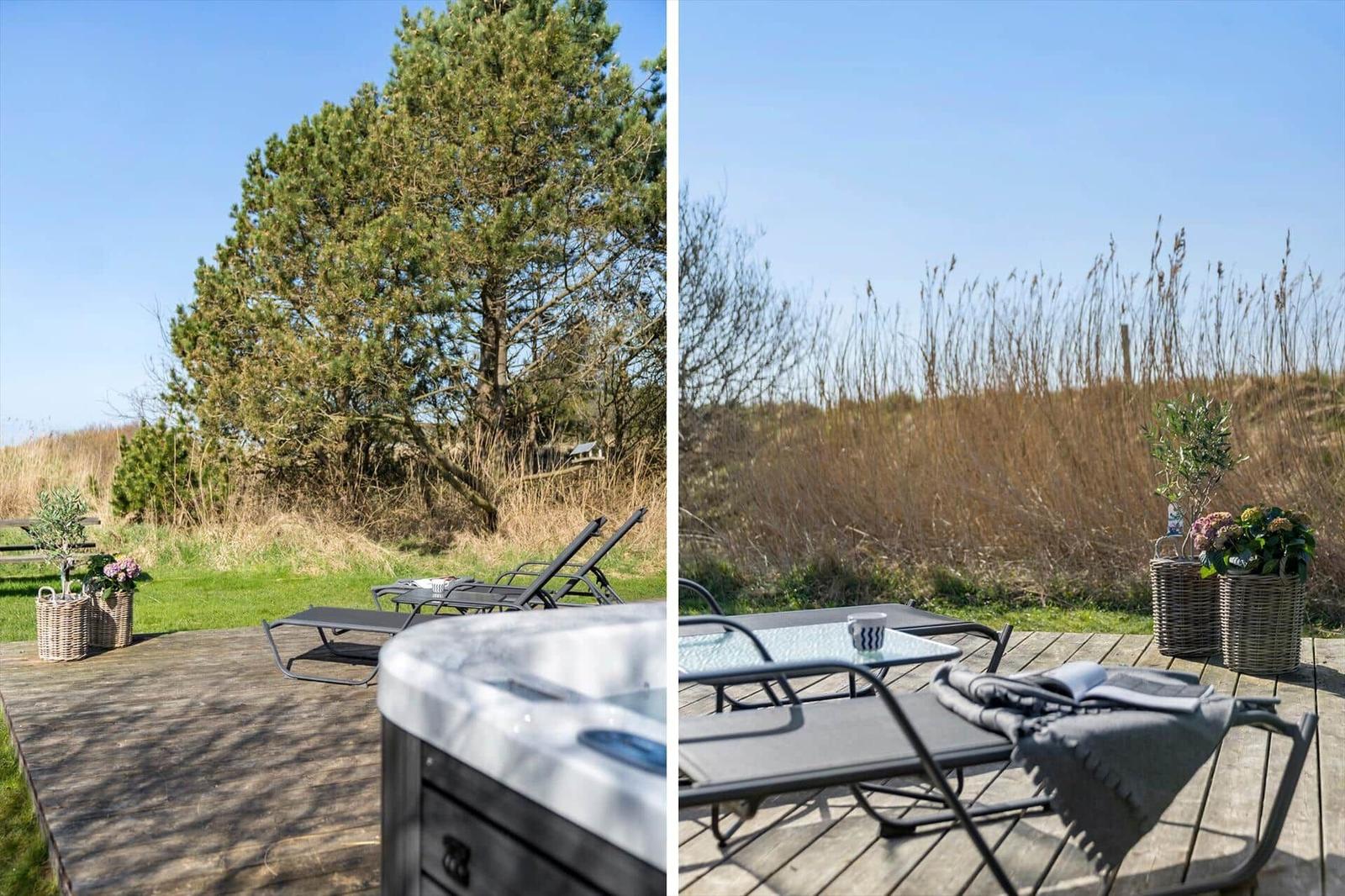 Terrasse mit Whirlpool, Sonnenliegen und Blick auf Gras und Bäume.