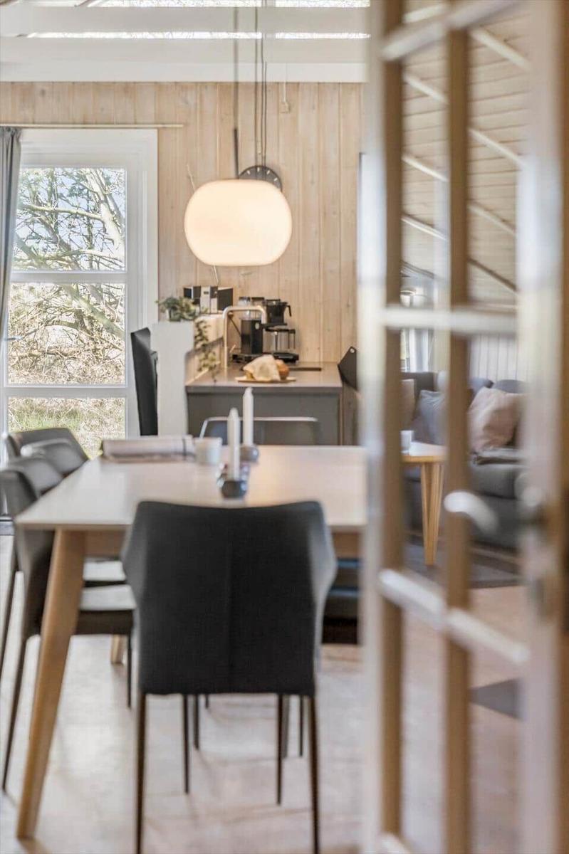 Essbereich mit Tisch, Stühlen und Blick auf Wohnzimmer.