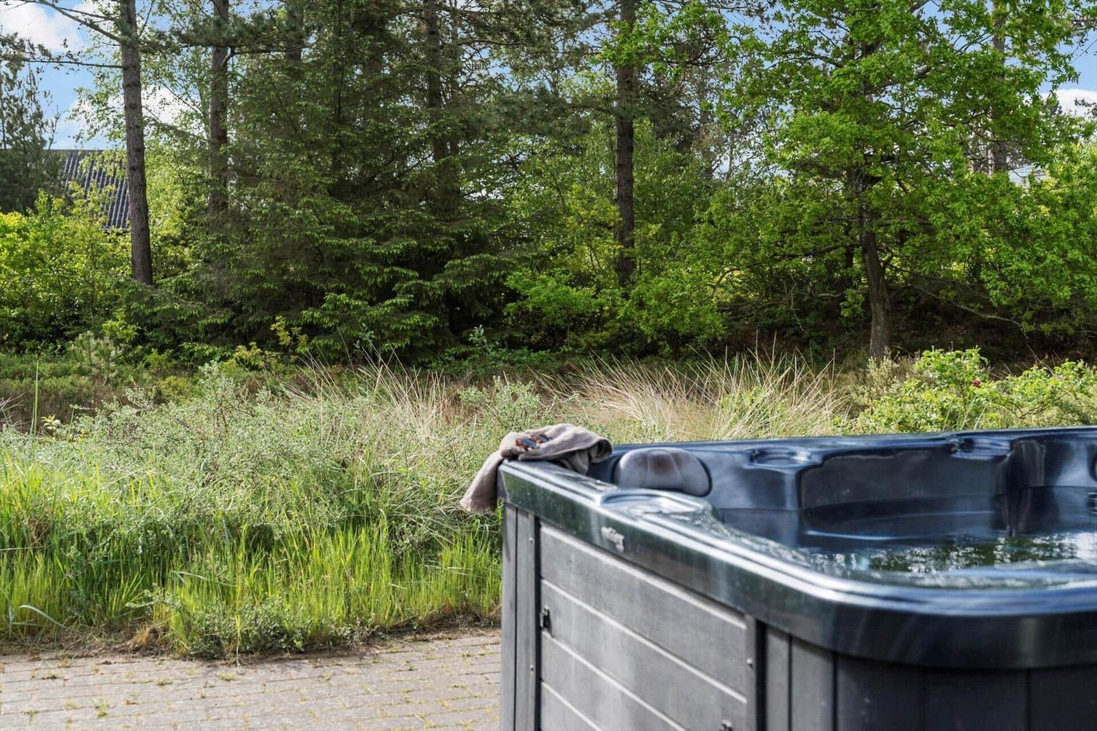 Ein Whirlpool im Freien mit Blick auf einen Wald und Gras.