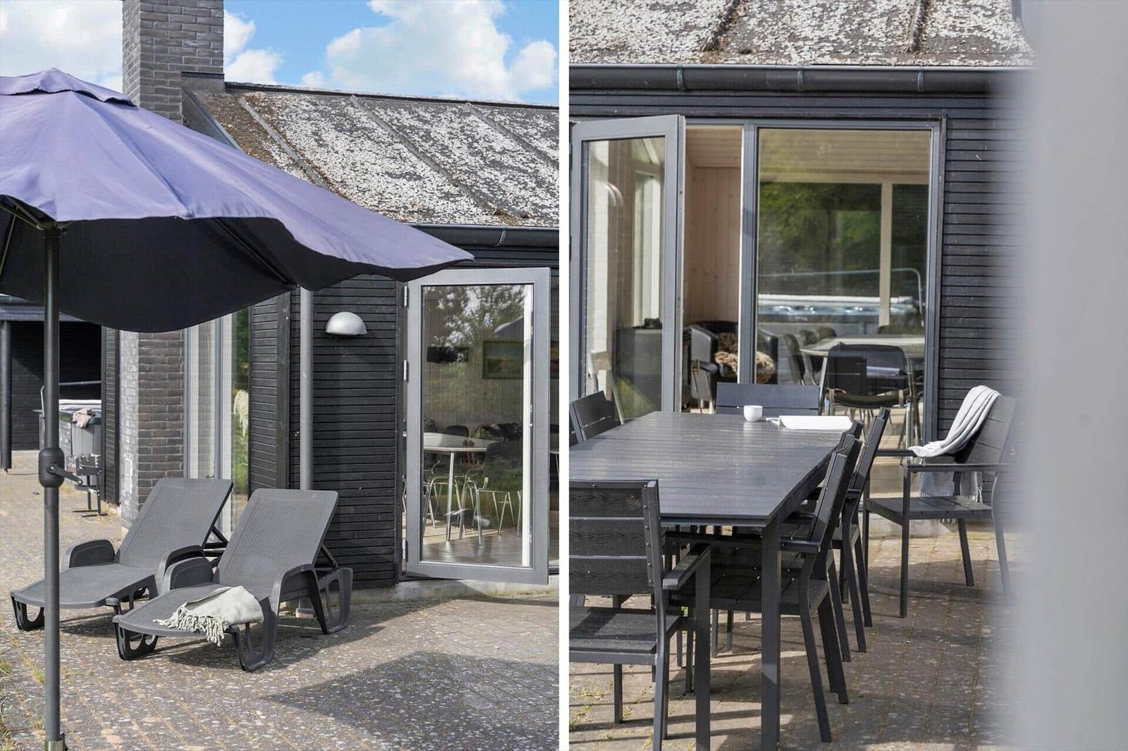 Terrasse mit Liegestühlen und Sonnenschirm. Tisch und Stühle für Essbereich.