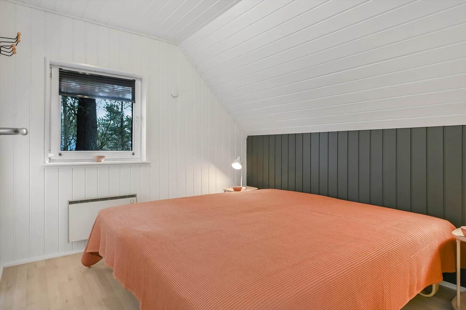 Schlafzimmer mit Bett, Fenster und Holzboden