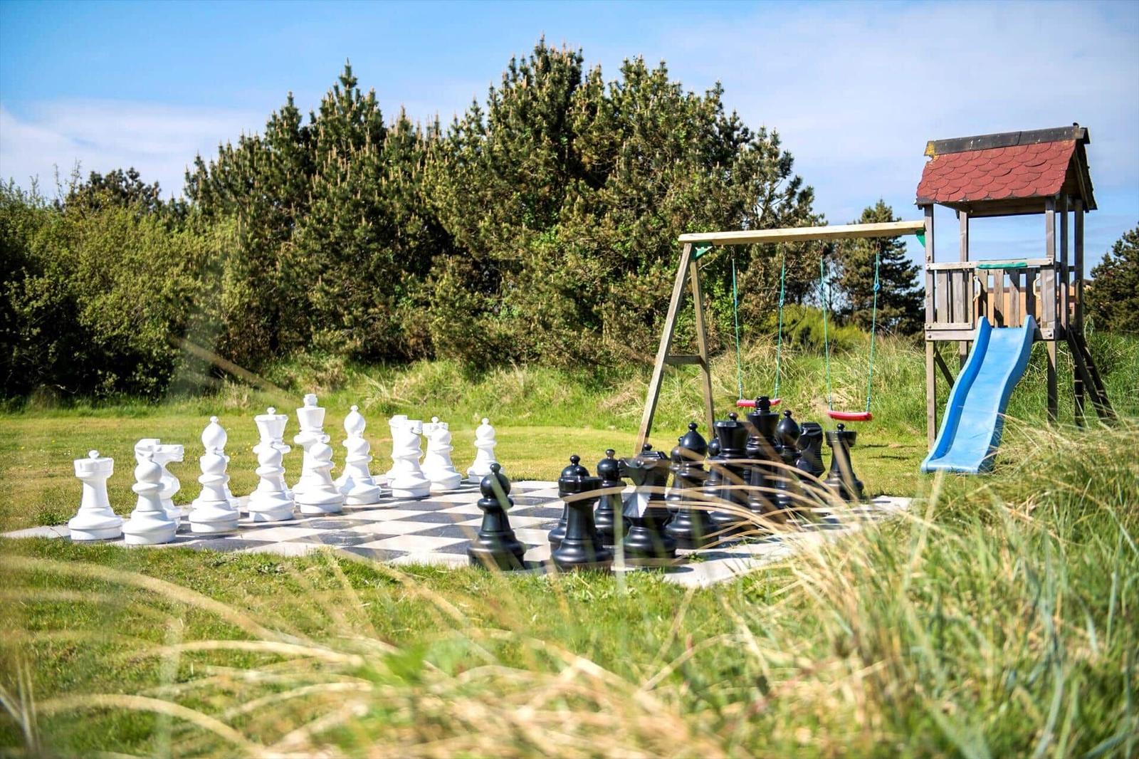 Großes Schachspiel im Garten mit Spielplatz und Rutsche.