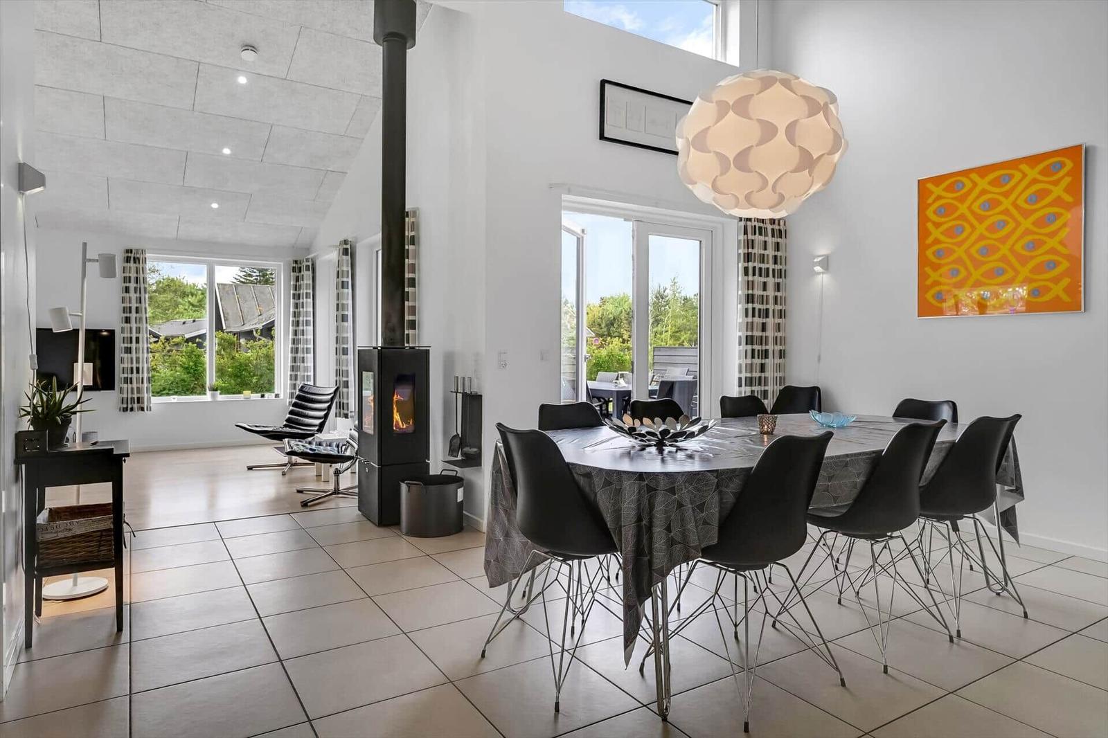 Essbereich mit Tisch und Stühlen, Kamin und Fenster zum Garten.