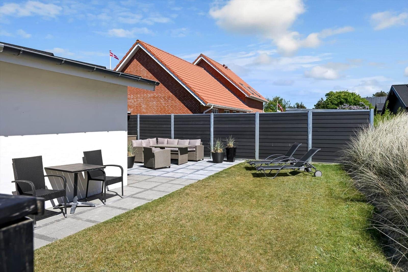 Hinterhof mit Terrasse, Liegestühlen und Garten. Hinterhof mit Terrasse, Liegestühlen und Garten.