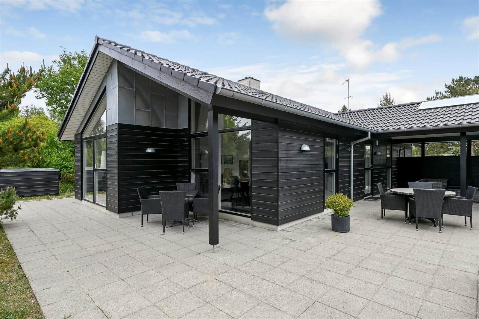 Moderne Villa mit großem Hof und Sitzgelegenheiten im Freien.