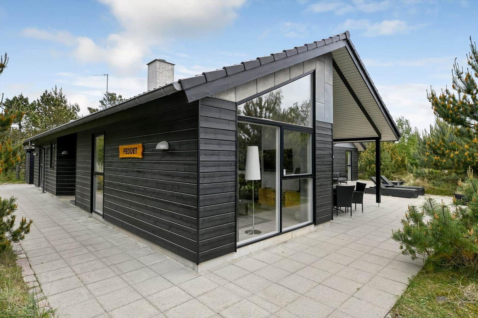 Moderne Holzhütte mit großem Glasbereich und Außenterrasse im Wald
