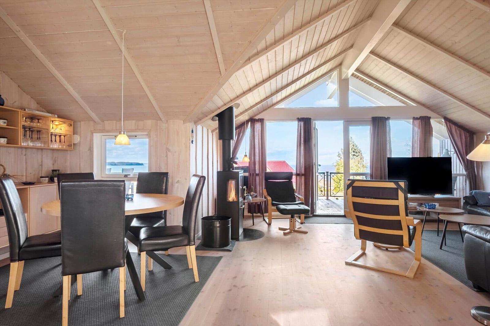 Wohnraum mit Essbereich, Kamin und Blick auf See