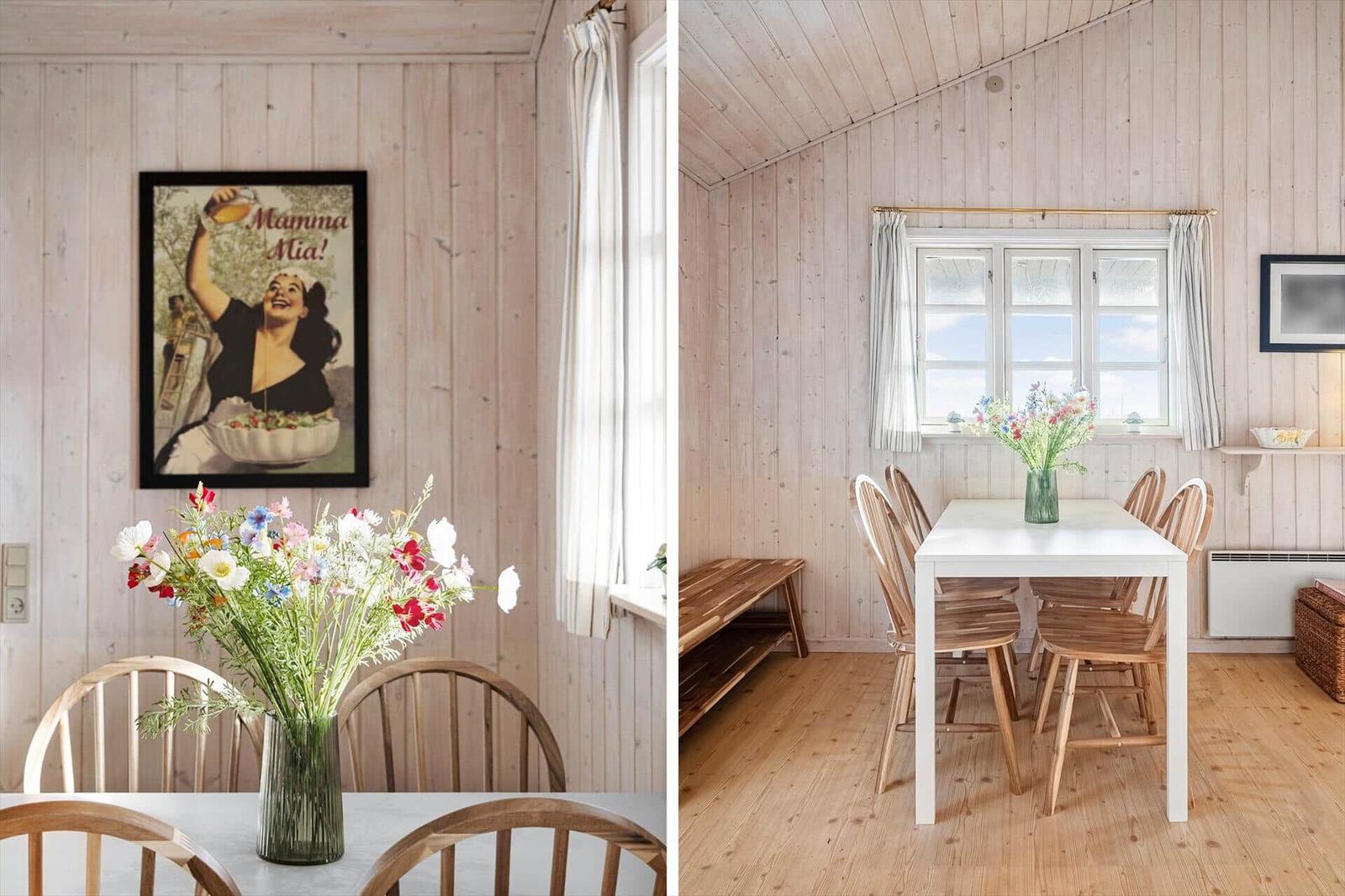 Dining room with wooden walls, table, chairs, and flowers. Wall poster with Mamma Mia!.