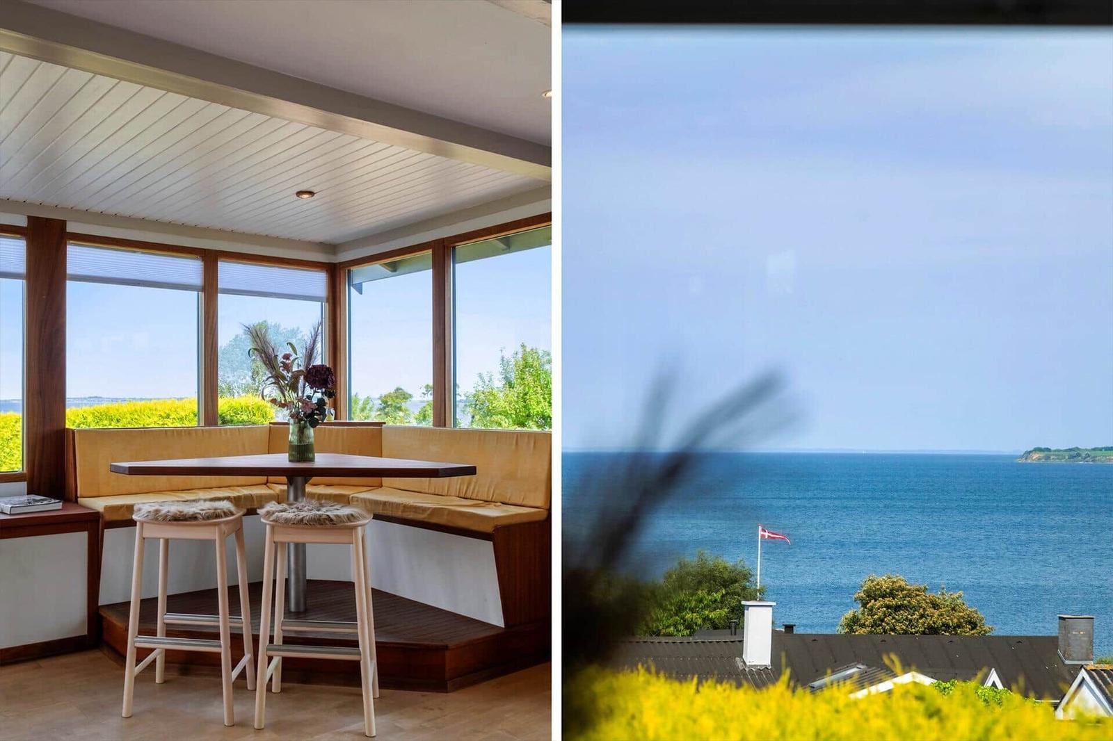 Sitzgelegenheit mit Tisch und Stühlen. Blick auf Meer und Flagge.