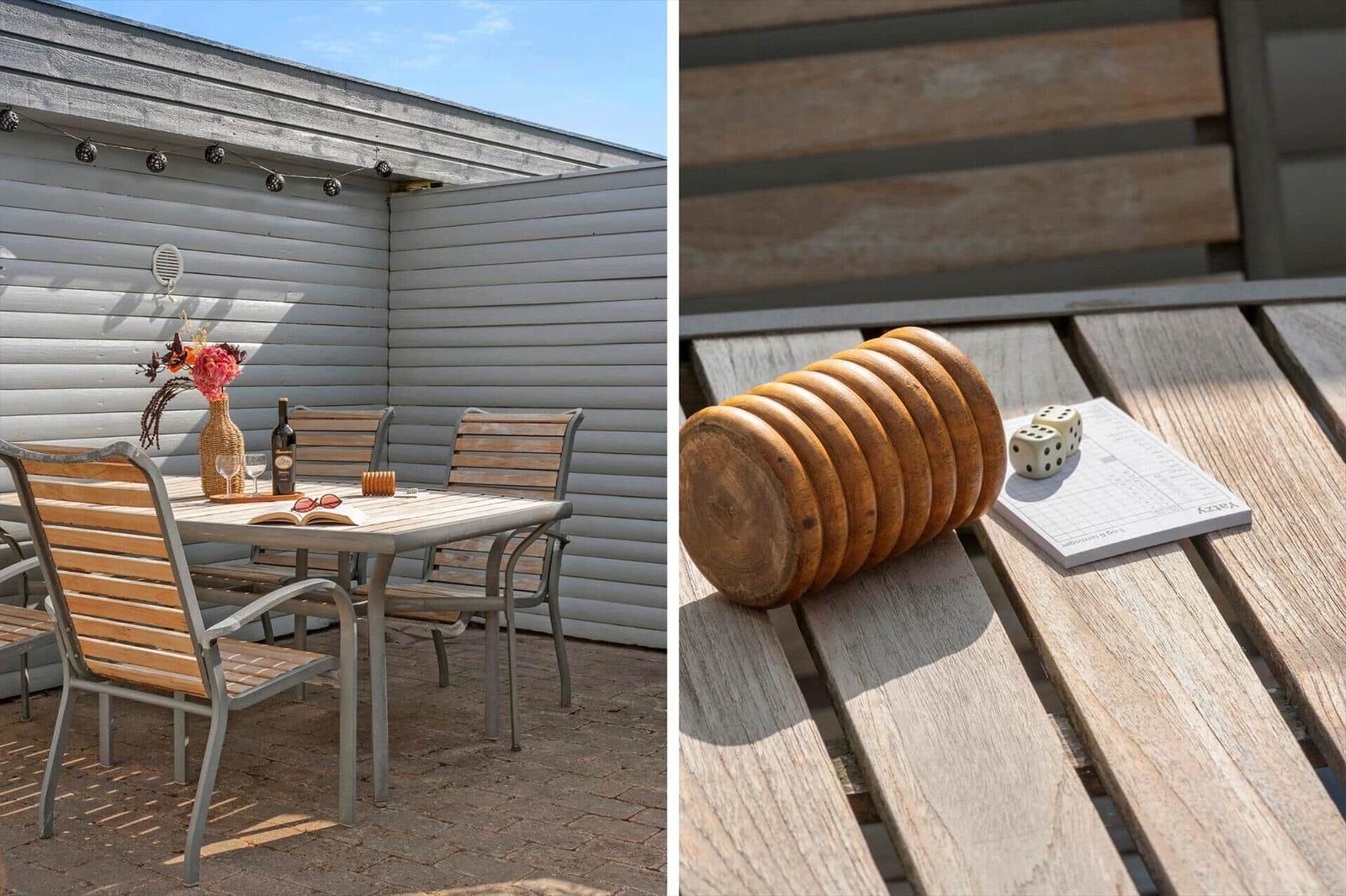 Terrasse mit Tisch und Stühlen, daneben Würfel und Brettspiel auf Holztisch.