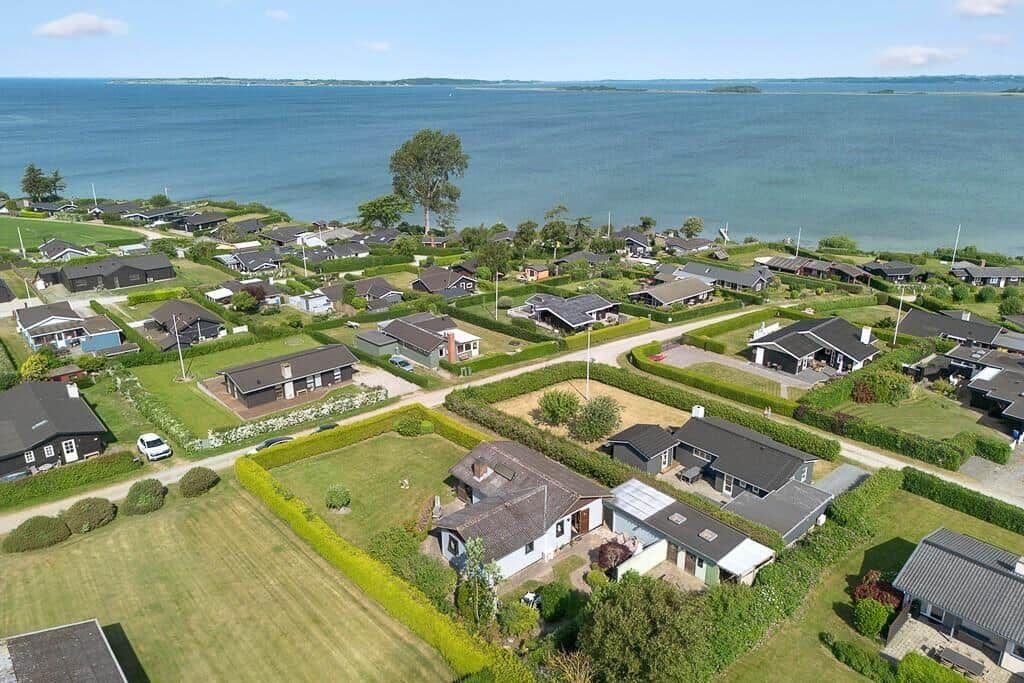 Überblick über Ferienhäuser am Wasser mit grünen Gärten und gepflasterten Wegen.