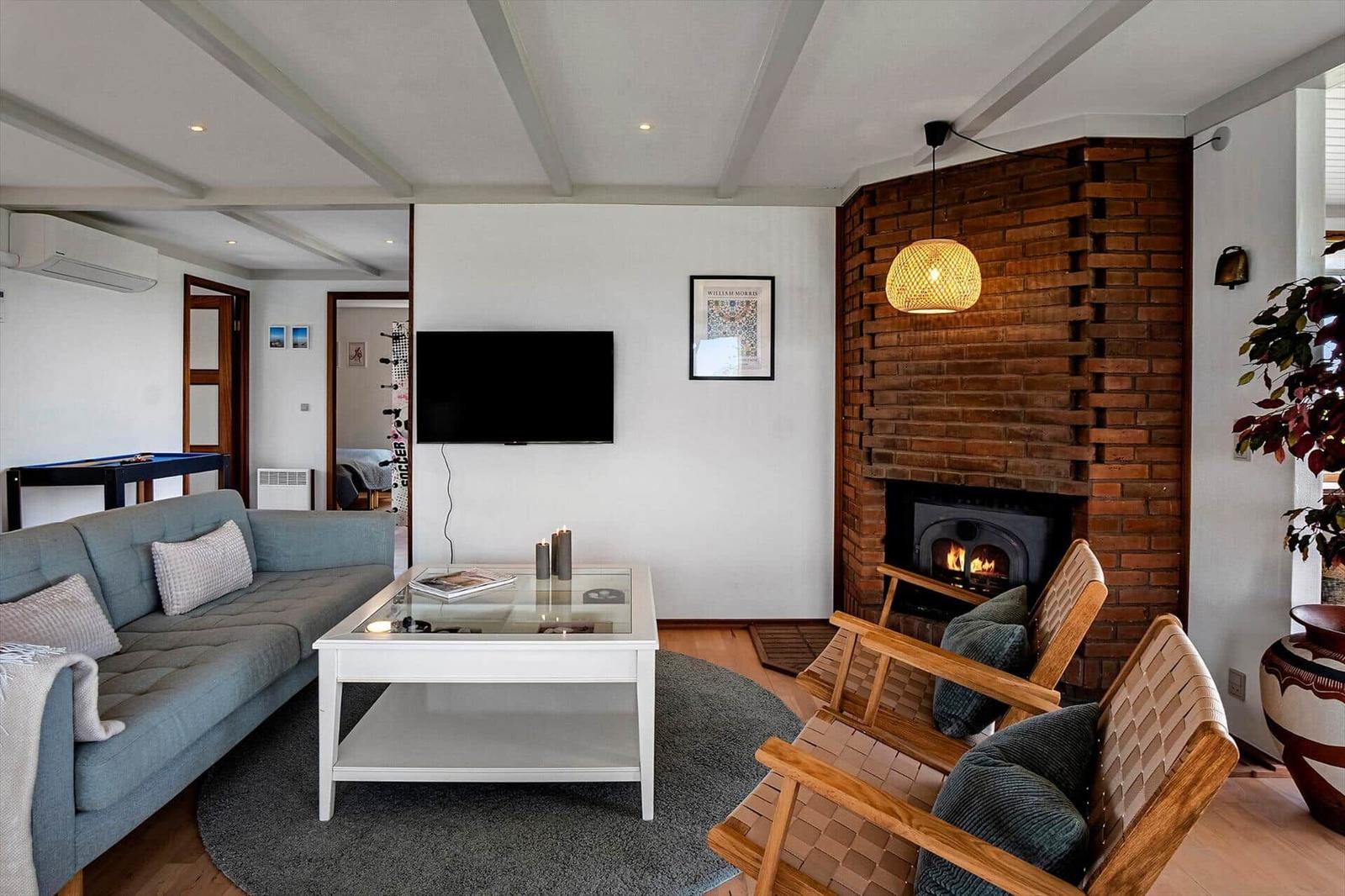 Wohnzimmer mit Sofa, Kamin und Fernseher