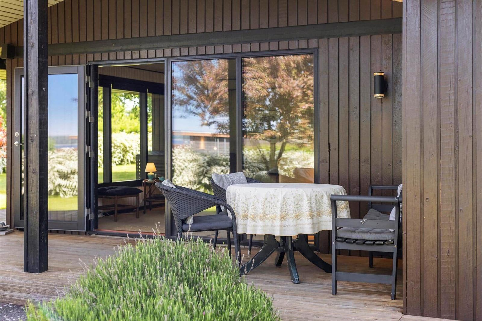 Terrace with table and chairs, access to interior via sliding door.