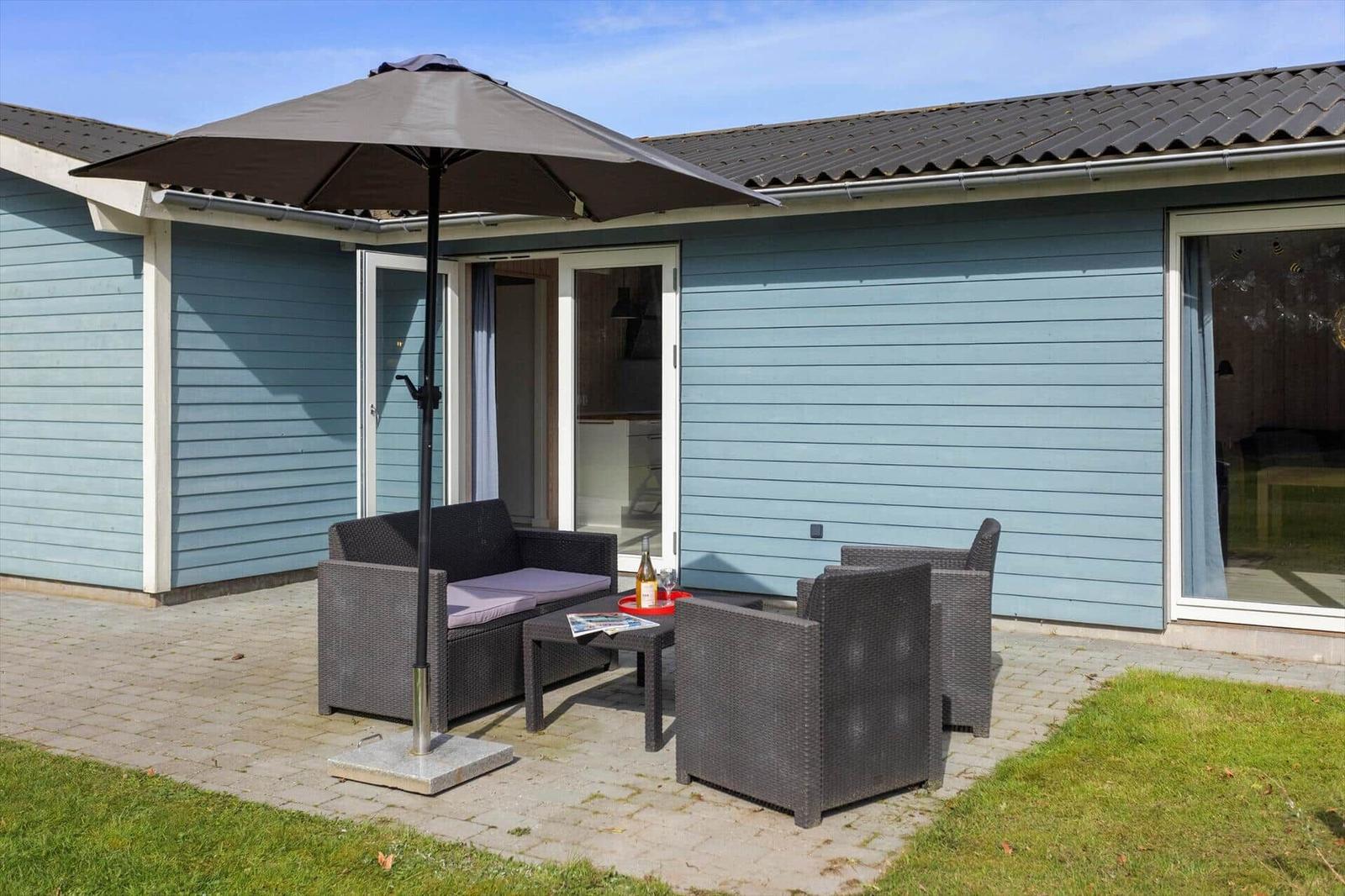 Terrace with seating group, umbrella, and view into the house.