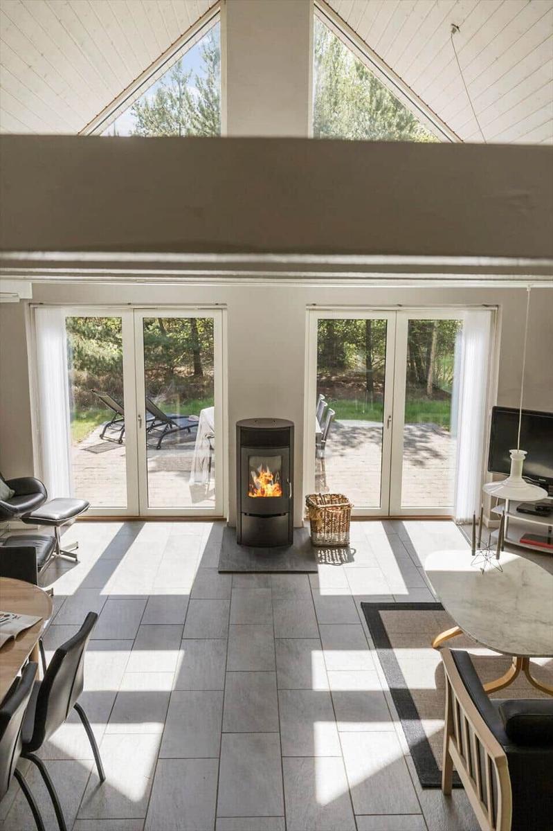 Wohnbereich mit Kamin, Glastüren und Blick auf den Garten
