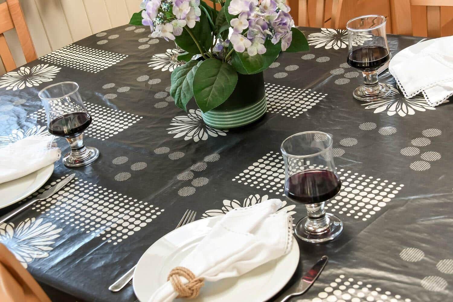 Table with tablecloth, wine, and flowers