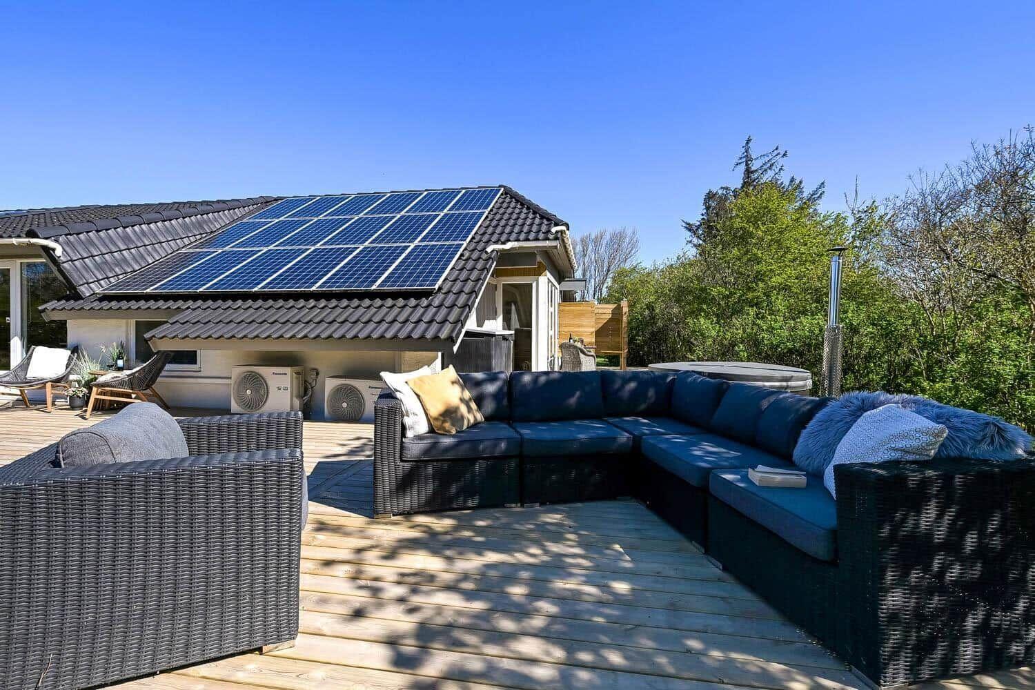 Terrasse mit großem Sitzbereich und Solaranlage auf dem Dach.