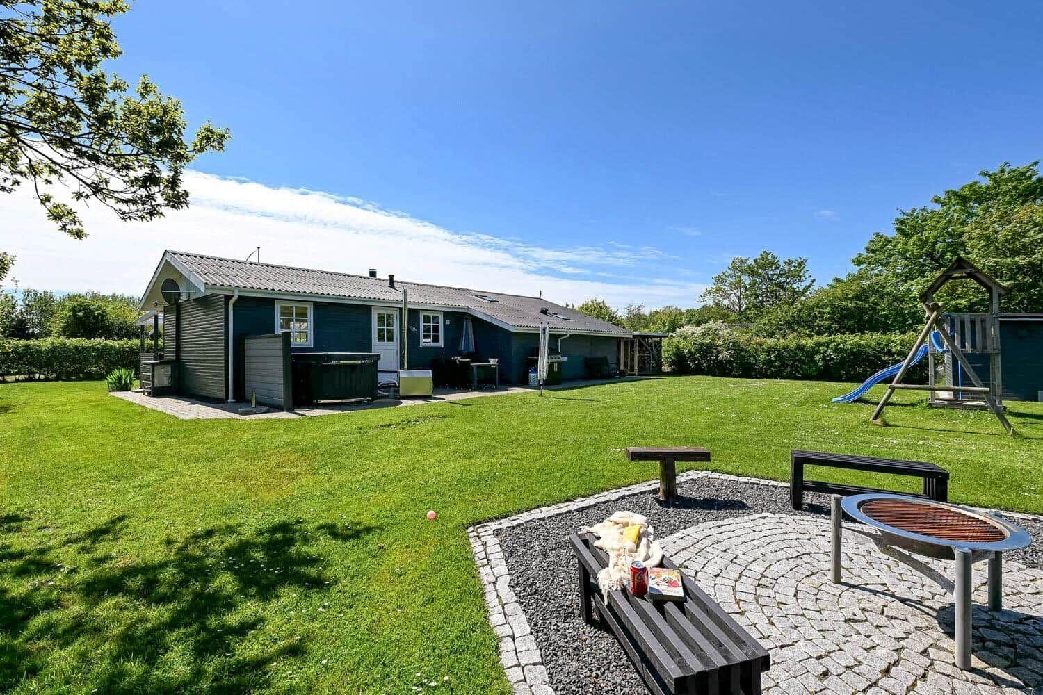 Ein Haus mit großem Garten, Spielplatz und Grillplatz im Freien.