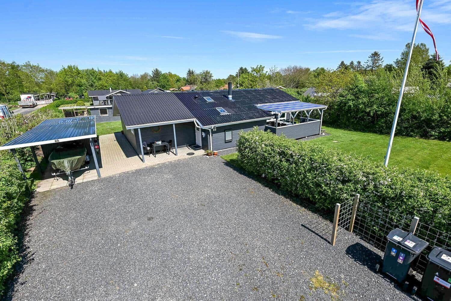 Ein Haus mit Garage, Terrasse und Garten. Eine Flagge weht im Wind.