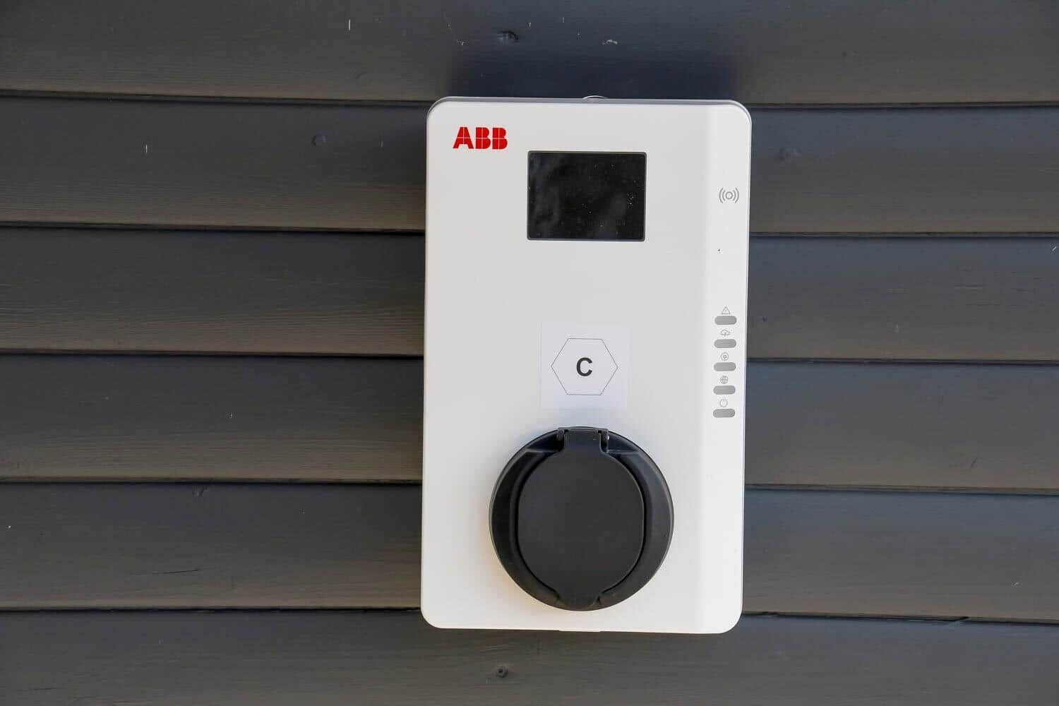 Ladestation an der Wand montiert mit Display und Steckdose.