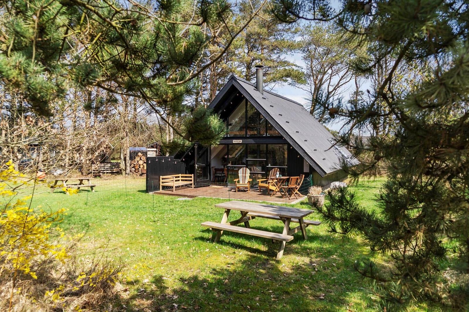 Moderne Hütte mit Terrasse und Picknicktisch im Wald