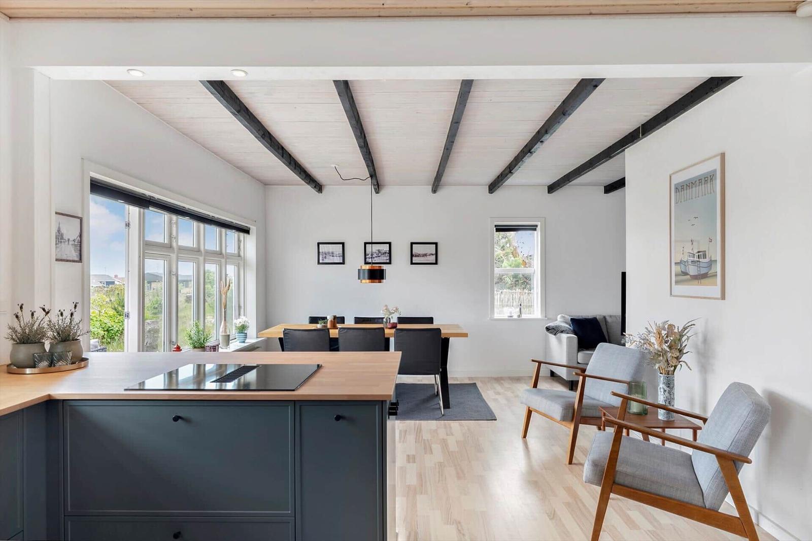 Küche mit Essbereich und Wohnzimmer mit Holzboden und Deckenbalken.