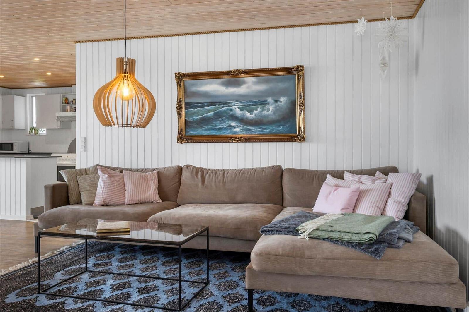 Living room with sofa, coffee table, and wall painting above the sofa.