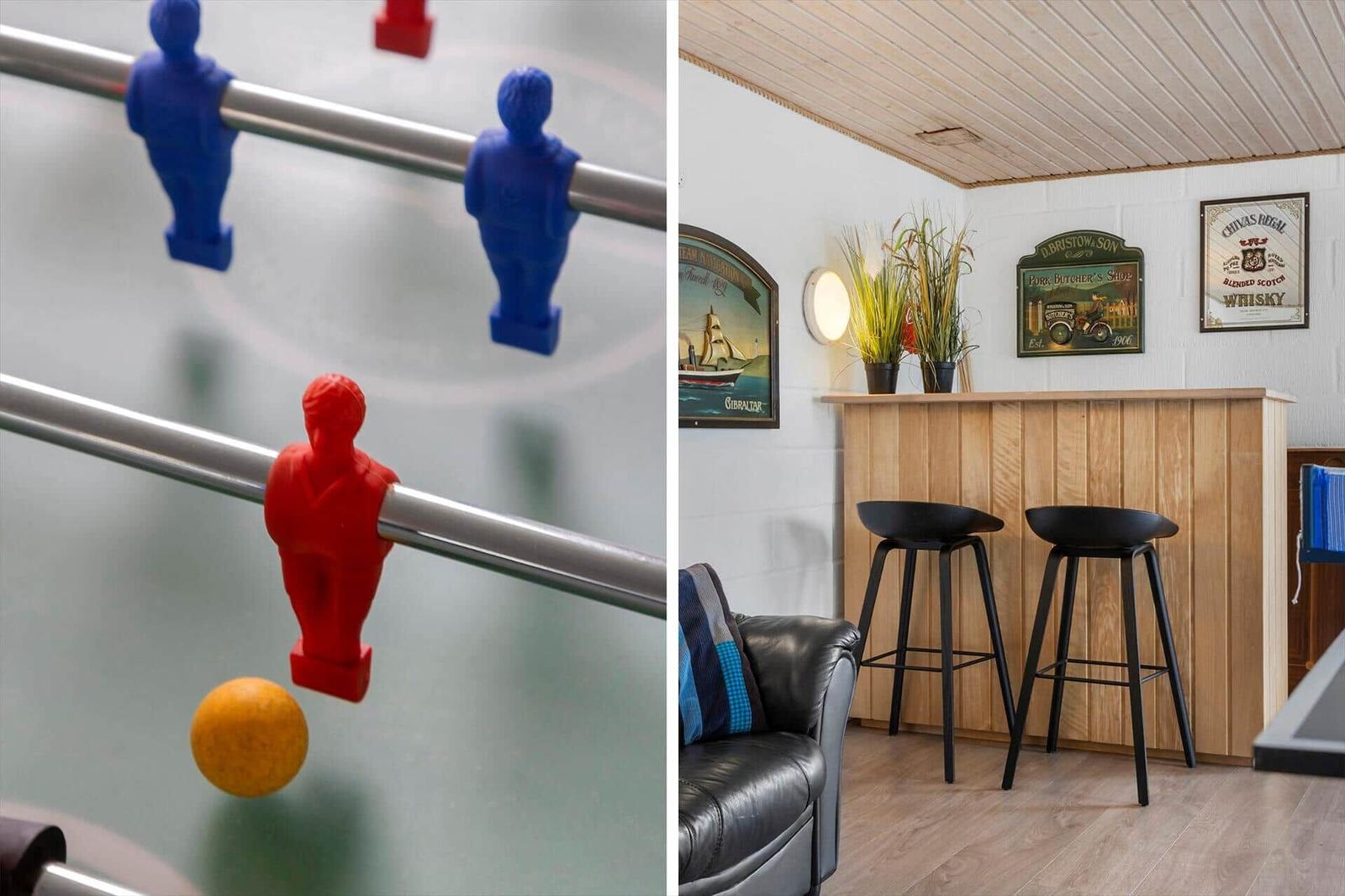 Foosball table and bar area with stools and wall decor.