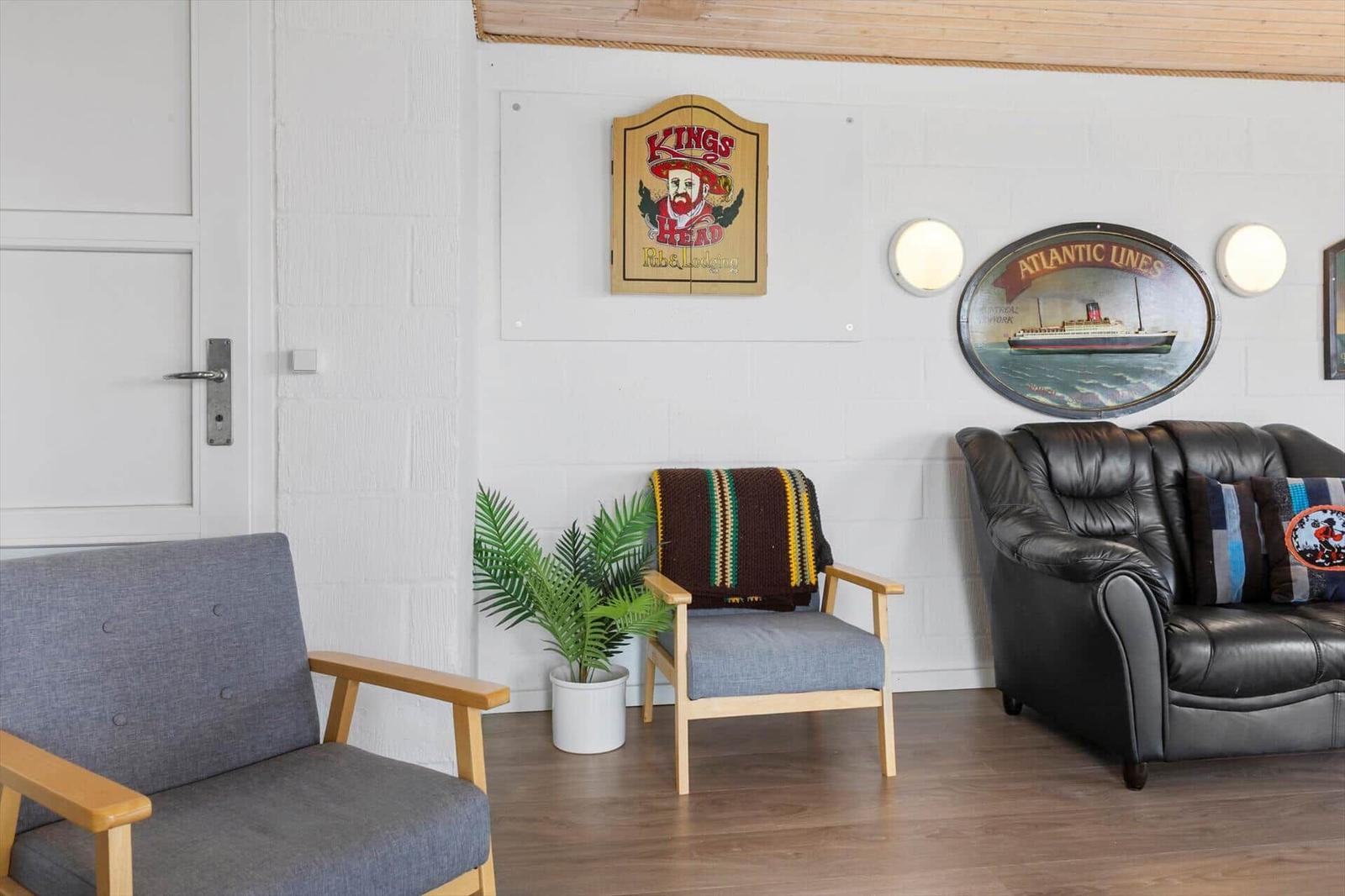 Living room with seating, plant, and wall decor.