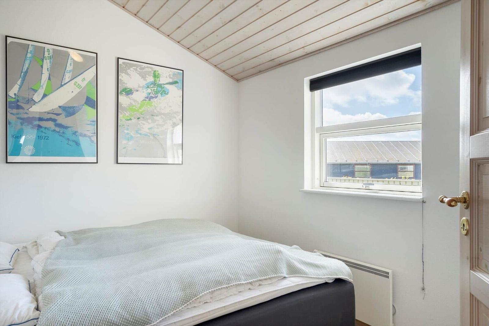 Bedroom with bed, window, and wall art