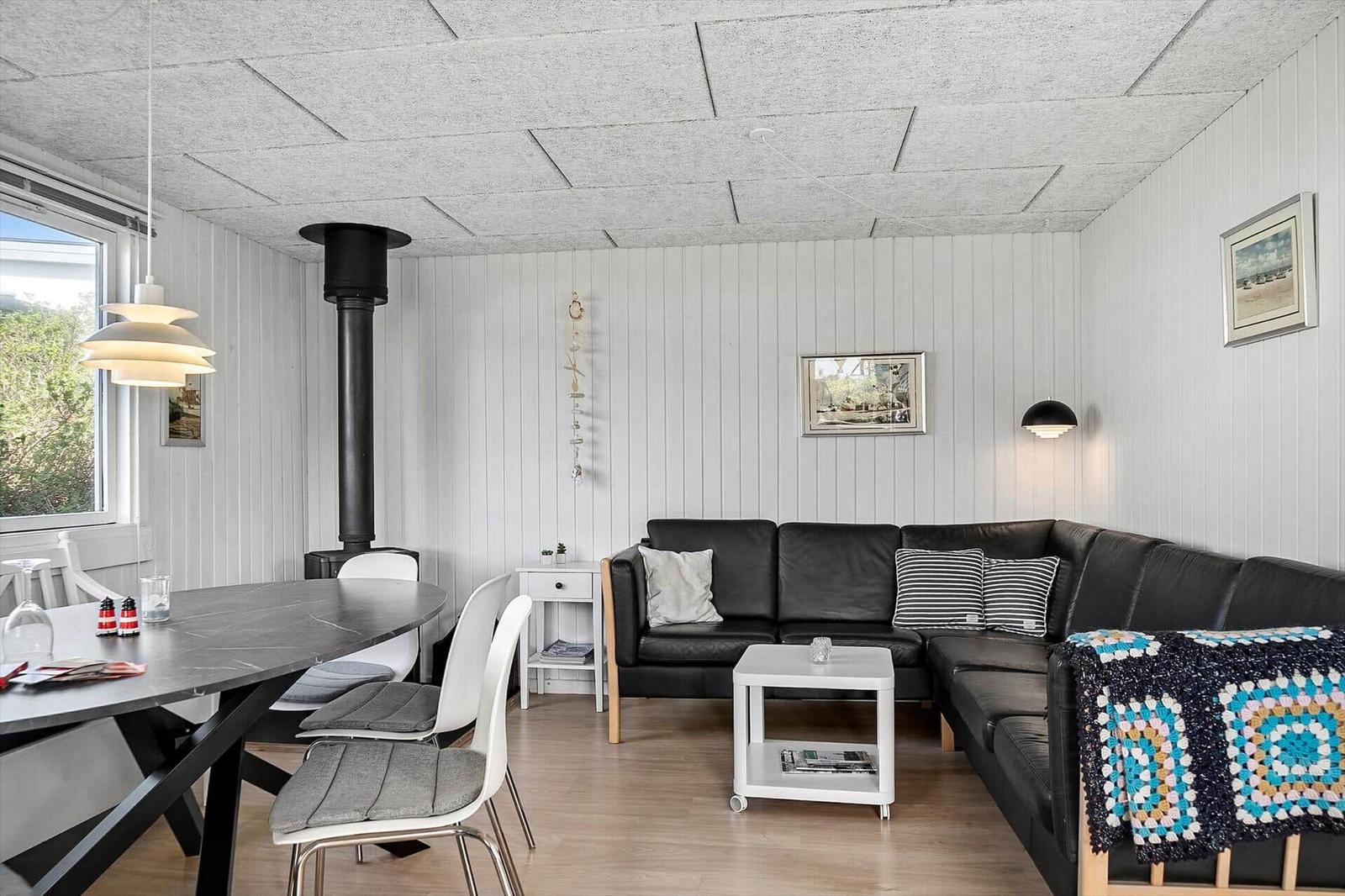 Wohn- und Essbereich mit Sofa, Esstisch und Kaminofen.