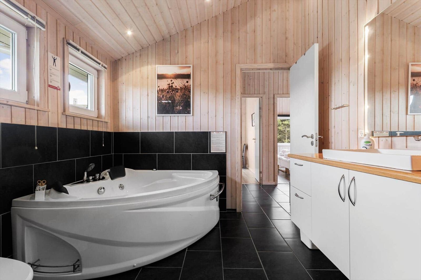 Bad mit Whirlpool, Holzwand und Waschtisch mit Spiegel