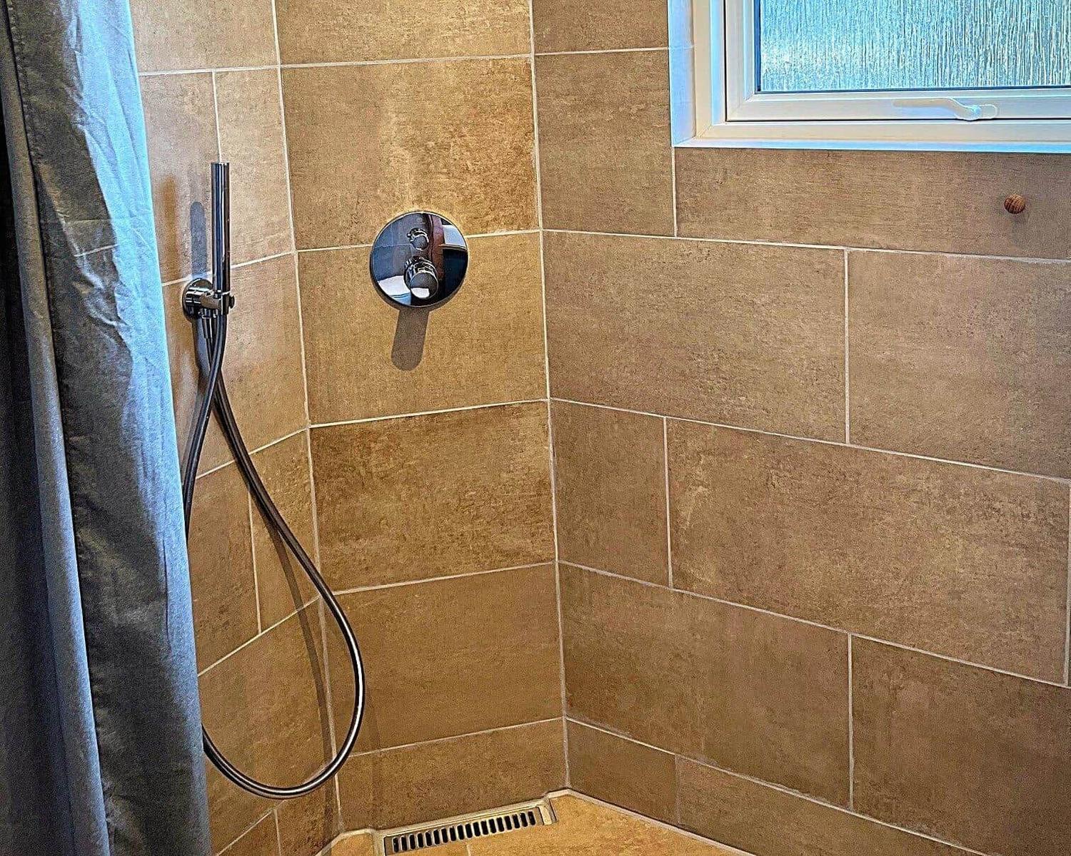 Dusche mit Duschbrause und Fenster