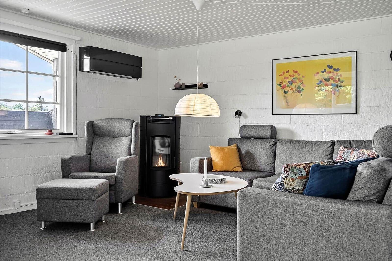 Living room with gray sofa, armchair, fireplace, and wall art.