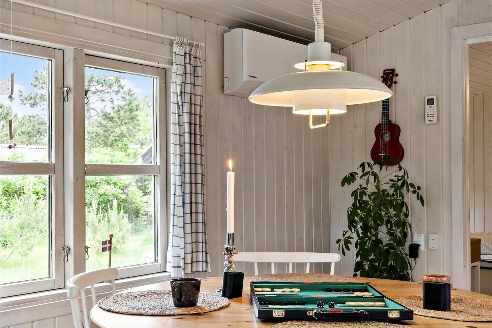Dining room with table, lamp, and view of garden.
