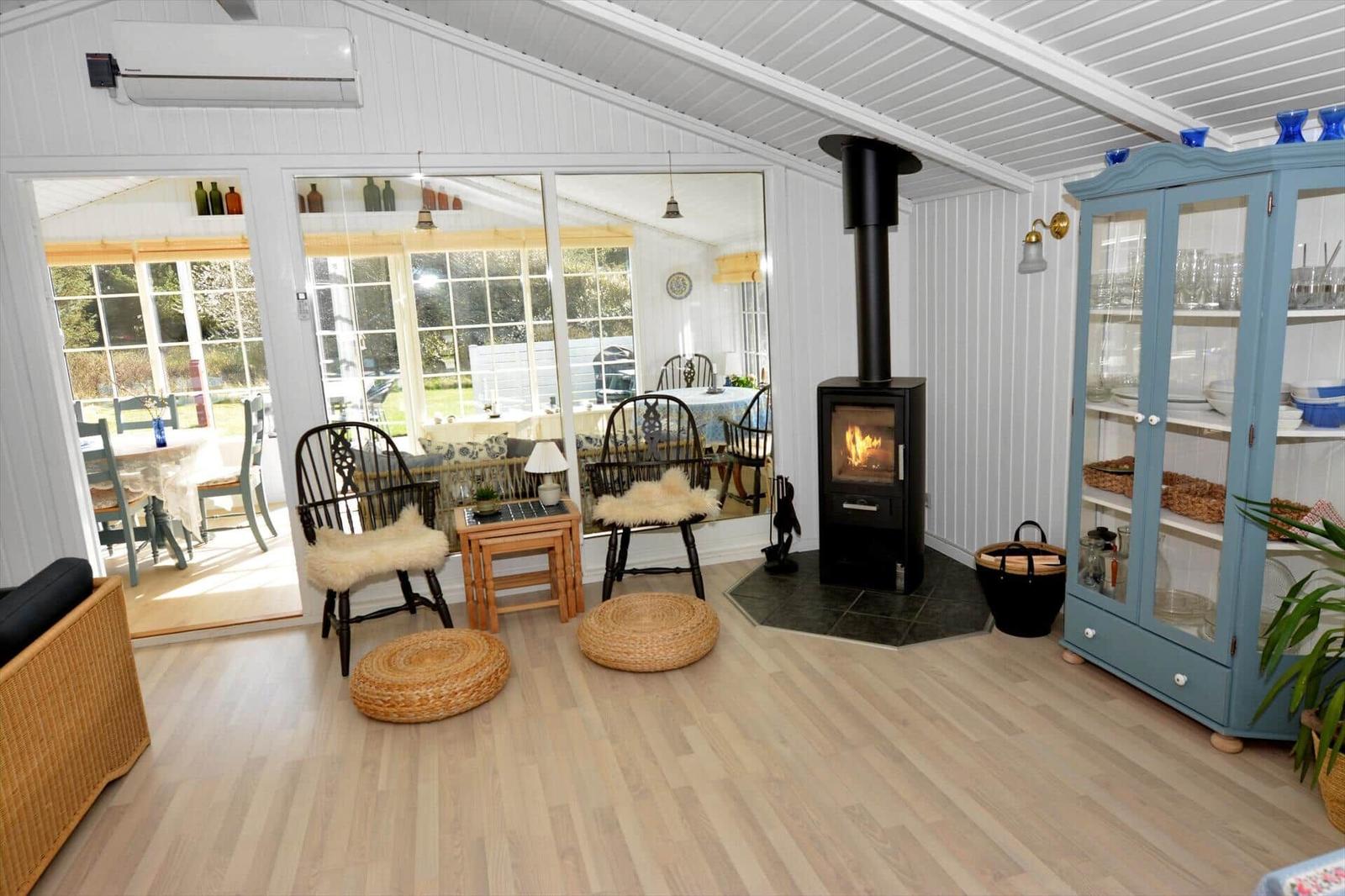 Wohnraum mit Kamin, Sitzgelegenheiten und Blick auf die Terrasse.