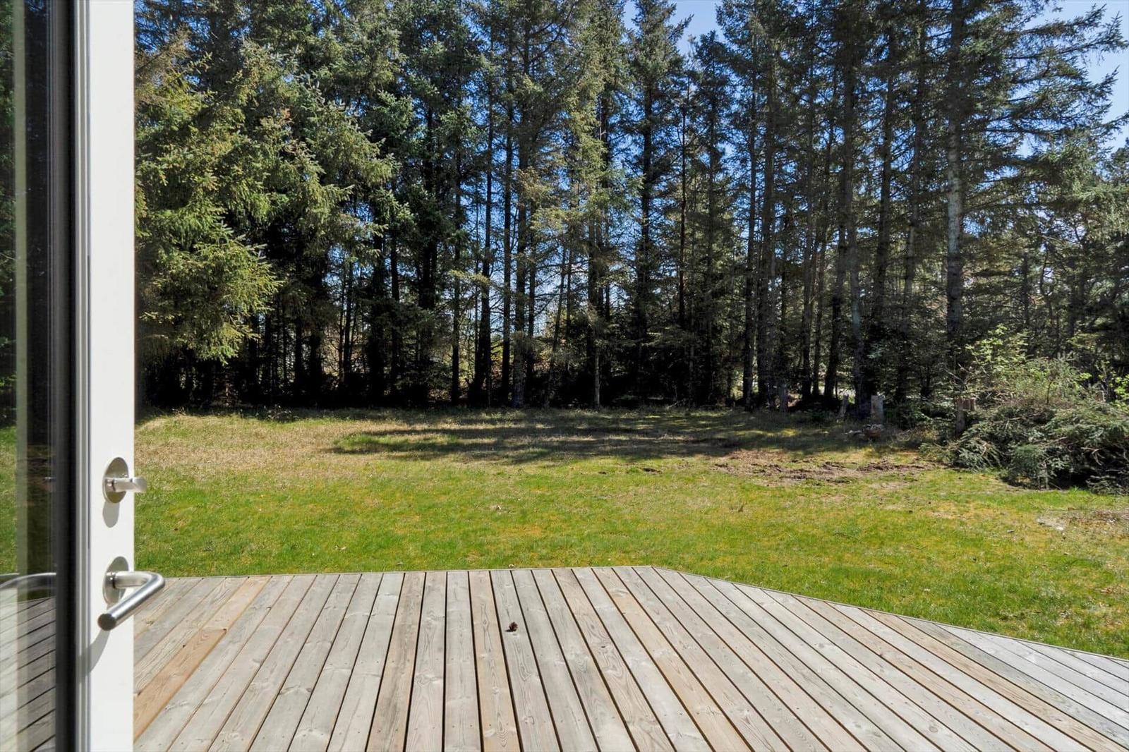 Terrasse mit Blick auf Wald und Grasfläche