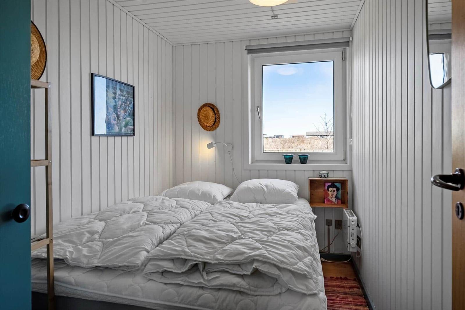 Bedroom with bed, window, and wall decor.