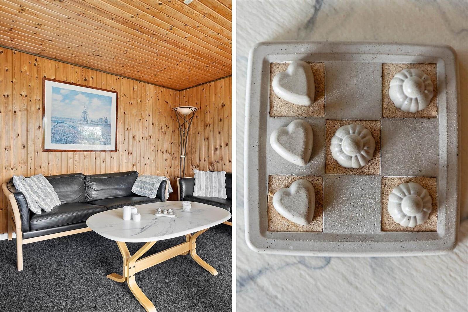 Wohnzimmer mit Holzwand und Sofa. Keramikobjekte auf Marmorplatte.