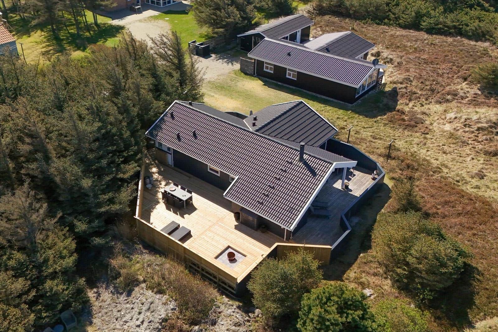 Haus mit Holzterrasse und Dachterrasse in Waldnähe
