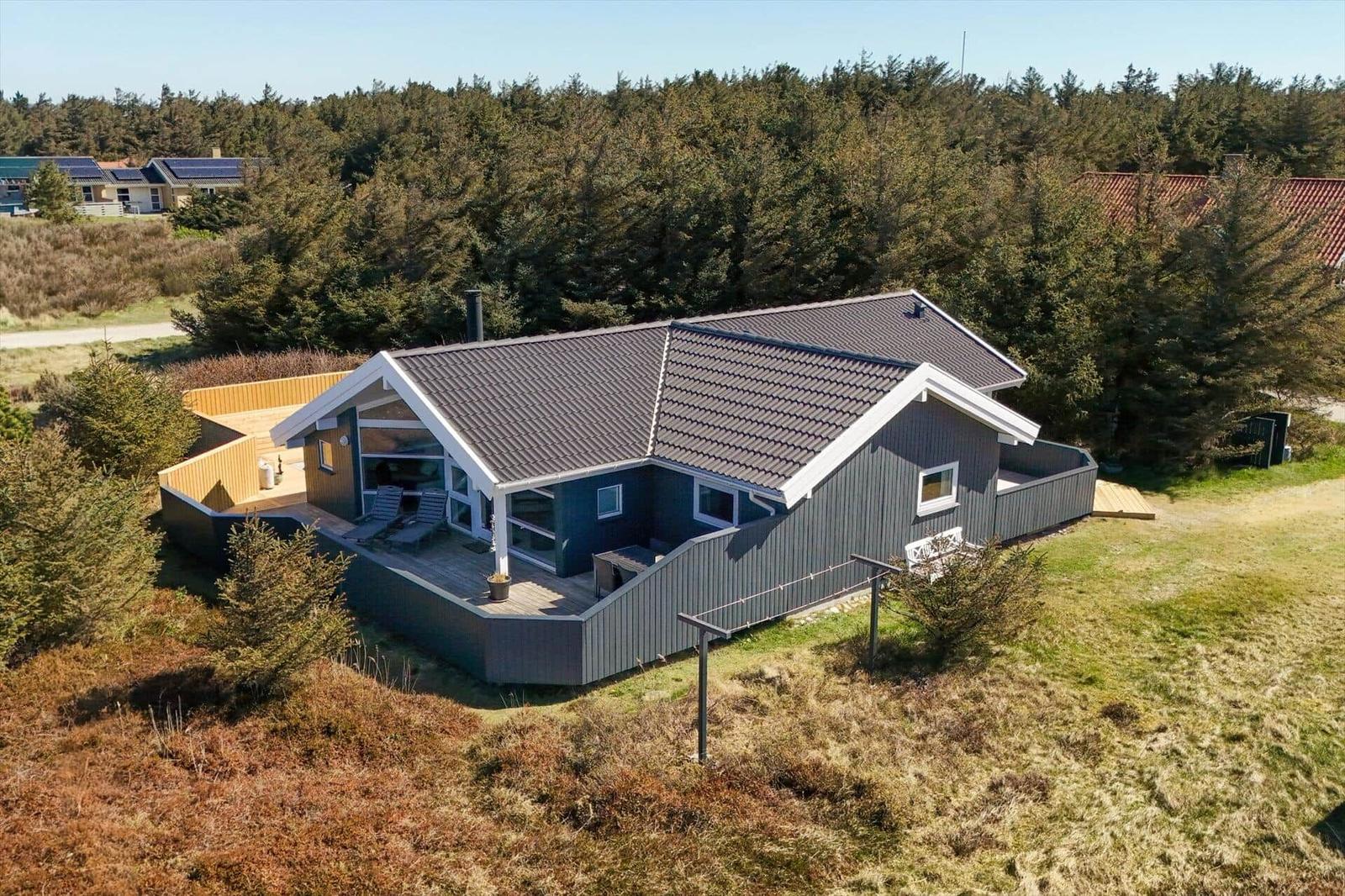 Ein Haus mit Terrasse und Garten, umgeben von Wald und Grasland.