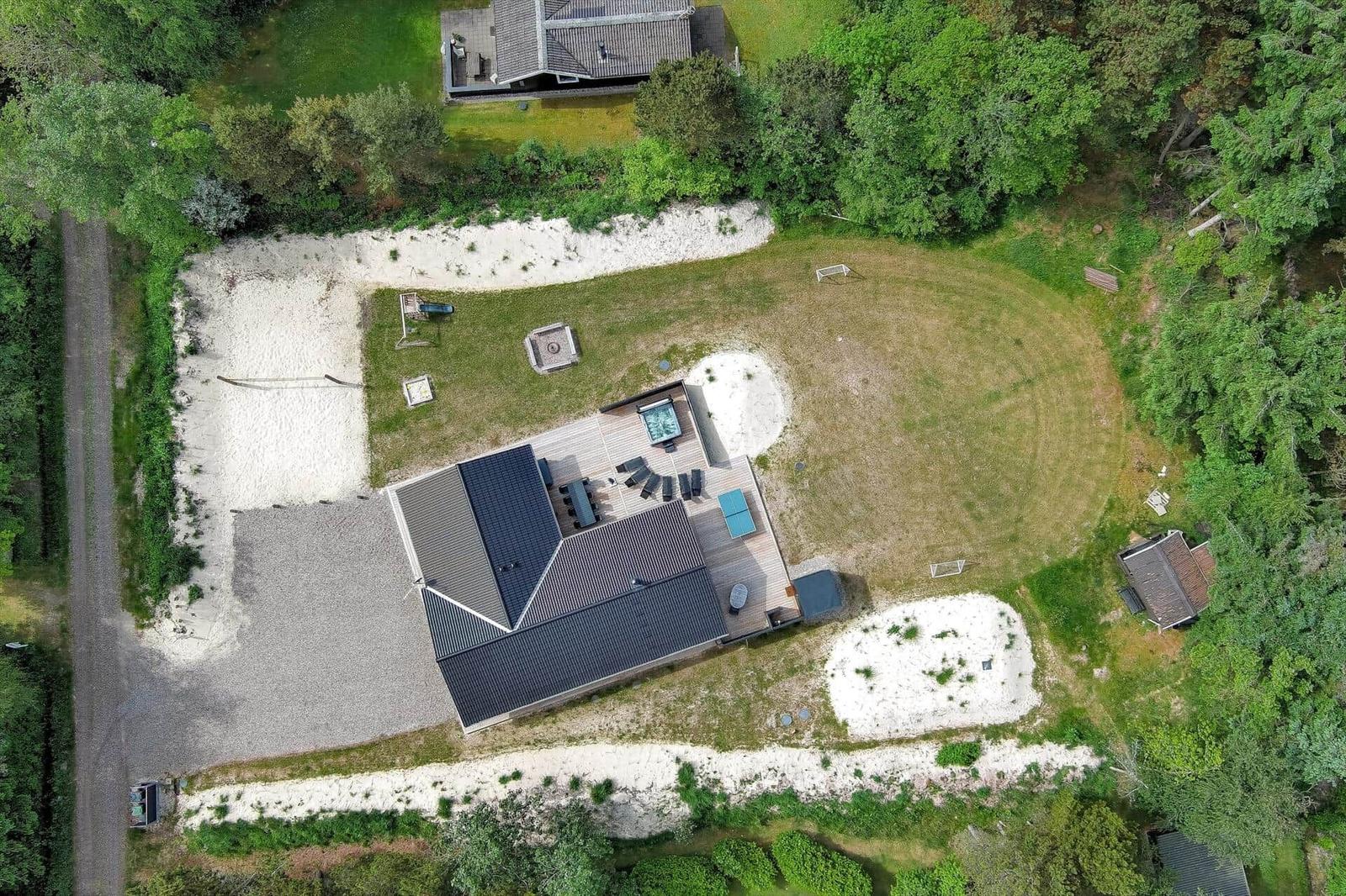Haus mit Pool, Terrasse und Garten. Umgeben von Wald und Sandflächen.