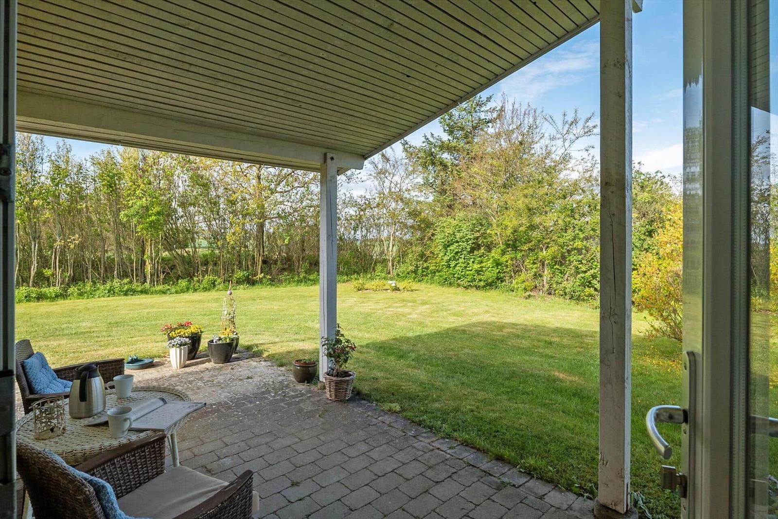 Porch with seating area and view of green lawn