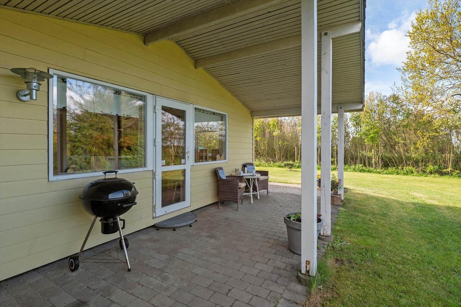 Patio with grill, seating area, and view of the garden.