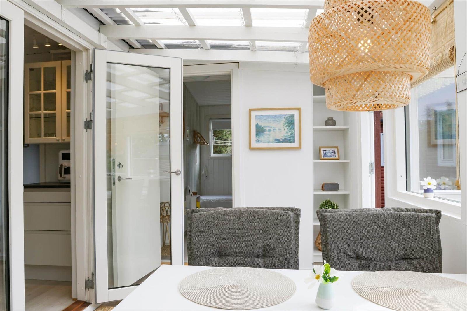 Essbereich mit Tisch, Stühlen und Deckenleuchte. Durchgang zu Küche und Schlafzimmer.
