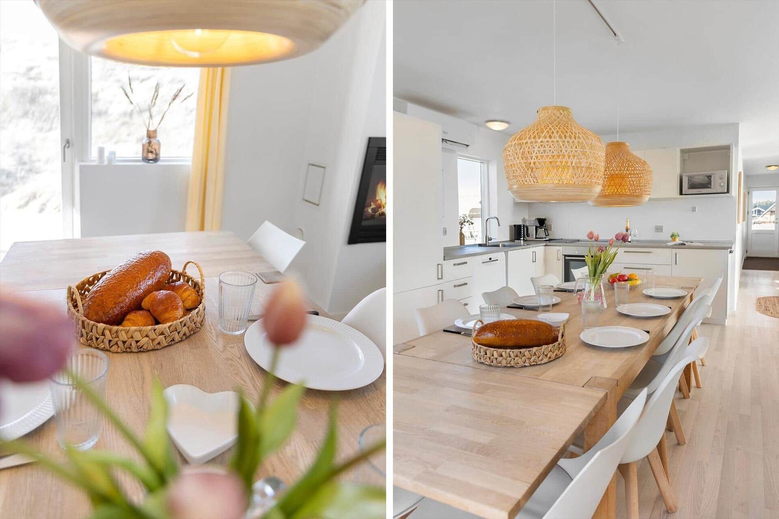 Esszimmer mit Holztisch, Stühlen und Korb mit Brot. Küche mit weißen Schränken und hängenden Lampen.